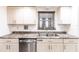 Galley kitchen with updated countertops, cabinets, and stainless steel dishwasher under a window at 11105 Pendleton Ave, Englewood, FL 34224