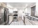 Updated kitchen with stainless steel appliances, granite countertops, white cabinets, and gray flooring at 11105 Pendleton Ave, Englewood, FL 34224