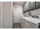 Functional laundry room features gray cabinets, a washing machine, and a dryer for efficient chores at 11105 Pendleton Ave, Englewood, FL 34224