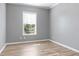 This bedroom features modern gray walls, wood laminate flooring, and a bright window at 11136 Grapefruit Ln, Punta Gorda, FL 33955