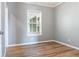 This bedroom features modern gray walls, wood laminate flooring, and a bright window at 11136 Grapefruit Ln, Punta Gorda, FL 33955