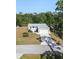 Aerial view of home featuring a two-car garage, mature trees, and a well manicured lawn at 11136 Grapefruit Ln, Punta Gorda, FL 33955