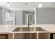 Close-up of kitchen sink, showcasing modern fixtures and open space into the dining and entry area at 11136 Grapefruit Ln, Punta Gorda, FL 33955