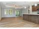 Open-concept living space with a kitchen island, wood floors, natural light, and access to a patio at 11136 Grapefruit Ln, Punta Gorda, FL 33955