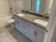 Modern bathroom with double sinks, granite countertops, white cabinets, and tile flooring at 112 Cougar Way, Rotonda West, FL 33947