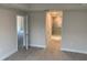 Spacious bedroom with wood-look tile flooring, neutral wall paint, and a view of an ensuite bathroom at 112 Cougar Way, Rotonda West, FL 33947