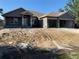 A charming single-story home featuring an attached two-car garage and a welcoming front porch at 112 Cougar Way, Rotonda West, FL 33947