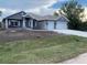 Beautiful single-story home featuring a 2-car garage, well-manicured lawn, and neutral-colored stucco finish at 112 Cougar Way, Rotonda West, FL 33947
