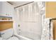 Bathroom featuring a toilet, shower-tub combo with grab bar, and convenient built-in shelving at 150 Harborside Ave # 134, Punta Gorda, FL 33950