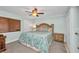 Comfortable bedroom with a decorative wooden headboard, ceiling fan and colorful floral bedding at 150 Harborside Ave # 134, Punta Gorda, FL 33950