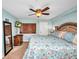 Well lit bedroom featuring light blue walls, a ceiling fan, tv, and decorative floral bedding at 150 Harborside Ave # 134, Punta Gorda, FL 33950