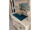 A vintage cabinet with decorative cupcakes on a teal tray, reflected in the mirror, showcasing charm and elegant display at 150 Harborside Ave # 134, Punta Gorda, FL 33950