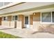 Exterior of condo unit, featuring front door, large windows, and a comfortable patio area at 150 Harborside Ave # 134, Punta Gorda, FL 33950