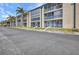 Exterior view of the building featuring multiple lanais and well-manicured landscaping at 150 Harborside Ave # 134, Punta Gorda, FL 33950