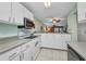 Galley kitchen with white cabinets, appliances, and countertops, offering lots of light at 150 Harborside Ave # 134, Punta Gorda, FL 33950