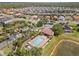 A community pool with a lake view, lounge chairs, and surrounding lush landscaping and trees at 15193 Mille Fiore Blvd, Port Charlotte, FL 33953