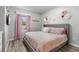 Bright bedroom featuring a queen-size bed, window, pink drapes and decorative wall art at 15193 Mille Fiore Blvd, Port Charlotte, FL 33953
