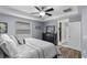 Bright bedroom featuring a king-size bed, ceiling fan, and ensuite bathroom at 15193 Mille Fiore Blvd, Port Charlotte, FL 33953