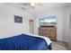 Bedroom with wooden bed, wood laminate flooring, and television on dresser at 15193 Mille Fiore Blvd, Port Charlotte, FL 33953