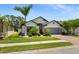 Charming single-Gathering home boasts a well-manicured lawn, brick driveway, and mature landscaping at 15193 Mille Fiore Blvd, Port Charlotte, FL 33953
