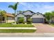 Charming single-Gathering home boasts a well-manicured lawn, brick driveway, and mature landscaping at 15193 Mille Fiore Blvd, Port Charlotte, FL 33953
