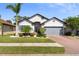Charming single-story home featuring a brick driveway and well-manicured lawn and landscaping at 15193 Mille Fiore Blvd, Port Charlotte, FL 33953