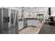 Well-lit kitchen with stainless appliances, wood flooring, and white cabinetry at 15193 Mille Fiore Blvd, Port Charlotte, FL 33953