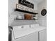 Charming laundry room with washer, dryer, decorative shelves and shiplap accent wall at 15193 Mille Fiore Blvd, Port Charlotte, FL 33953