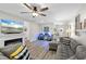 Inviting living room with a cozy fireplace, modern ceiling fan, and stylish gray sectional at 15193 Mille Fiore Blvd, Port Charlotte, FL 33953