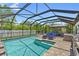 Private screened-in pool area, surrounded by lush landscaping and an outdoor kitchen at 15193 Mille Fiore Blvd, Port Charlotte, FL 33953