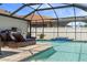 A screened-in pool area, complete with sun loungers and an outdoor kitchen for enjoyable outdoor living at 15193 Mille Fiore Blvd, Port Charlotte, FL 33953