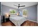 This bedroom features hard wood floors, a ceiling fan, and windows with blinds for natural light at 1773 Portage St, North Port, FL 34287