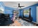 This bedroom features blue walls, hard wood floors, a ceiling fan, and lots of shelving at 1773 Portage St, North Port, FL 34287