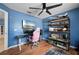 Bedroom with hard wood floors, a ceiling fan, blue walls and shelves with miniatures at 1773 Portage St, North Port, FL 34287