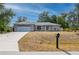 Inviting single-story home with a lush front lawn, a driveway leading to a garage, and a mailbox at 1773 Portage St, North Port, FL 34287