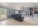 Spacious living room featuring tile flooring, a ceiling fan, and a comfortable leather sofa at 1773 Portage St, North Port, FL 34287