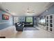 Comfortable living room with tile floors, a large sectional sofa, entertainment center, and natural light at 1773 Portage St, North Port, FL 34287