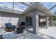 Covered patio with seating, a fire pit, and an entrance to the backyard at 1773 Portage St, North Port, FL 34287
