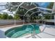 Screened in backyard pool with white fencing, shrubbery, and outdoor lounge area at 1773 Portage St, North Port, FL 34287