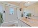 Bright bathroom with a combined bathtub and shower, vanity, mirror and toilet at 18135 Lake Worth Blvd, Port Charlotte, FL 33948