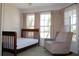 Bedroom with a chair and a crib, with many windows and natural light at 18135 Lake Worth Blvd, Port Charlotte, FL 33948