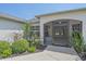 Close-up of the home's entrance, featuring a screened-in porch and lovely landscaping at 18135 Lake Worth Blvd, Port Charlotte, FL 33948