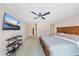 Comfortable main bedroom with a ceiling fan, large bed, and a mounted television at 18135 Lake Worth Blvd, Port Charlotte, FL 33948