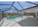 Outdoor pool area featuring a pool, open patio and lush landscaping beyond the screen at 18135 Lake Worth Blvd, Port Charlotte, FL 33948