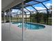 Backyard pool with a screened in porch and blue skies above the home at 18135 Lake Worth Blvd, Port Charlotte, FL 33948
