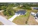 Aerial view of the property showing a well-manicured lawn, landscaping, and long driveway at 1816 Braddock Ave, North Port, FL 34288
