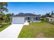 Charming single-story home with a well-manicured lawn, front garden, and a two-car garage at 1816 Braddock Ave, North Port, FL 34288