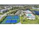Aerial view of community pool, clubhouse, and tennis courts amid lush landscaping at 2061 Willow Hammock Cir # 303, Punta Gorda, FL 33983