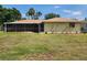 Backyard view of the home with a screened lanai, offering outdoor living space at 21035 Exmore Ave, Port Charlotte, FL 33952