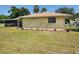 Rear exterior with small plumeria trees and a screen patio at 21035 Exmore Ave, Port Charlotte, FL 33952